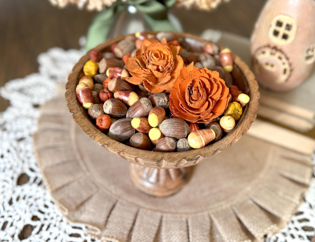 Decorative bowl with orange flowers and nuts on a textured surface