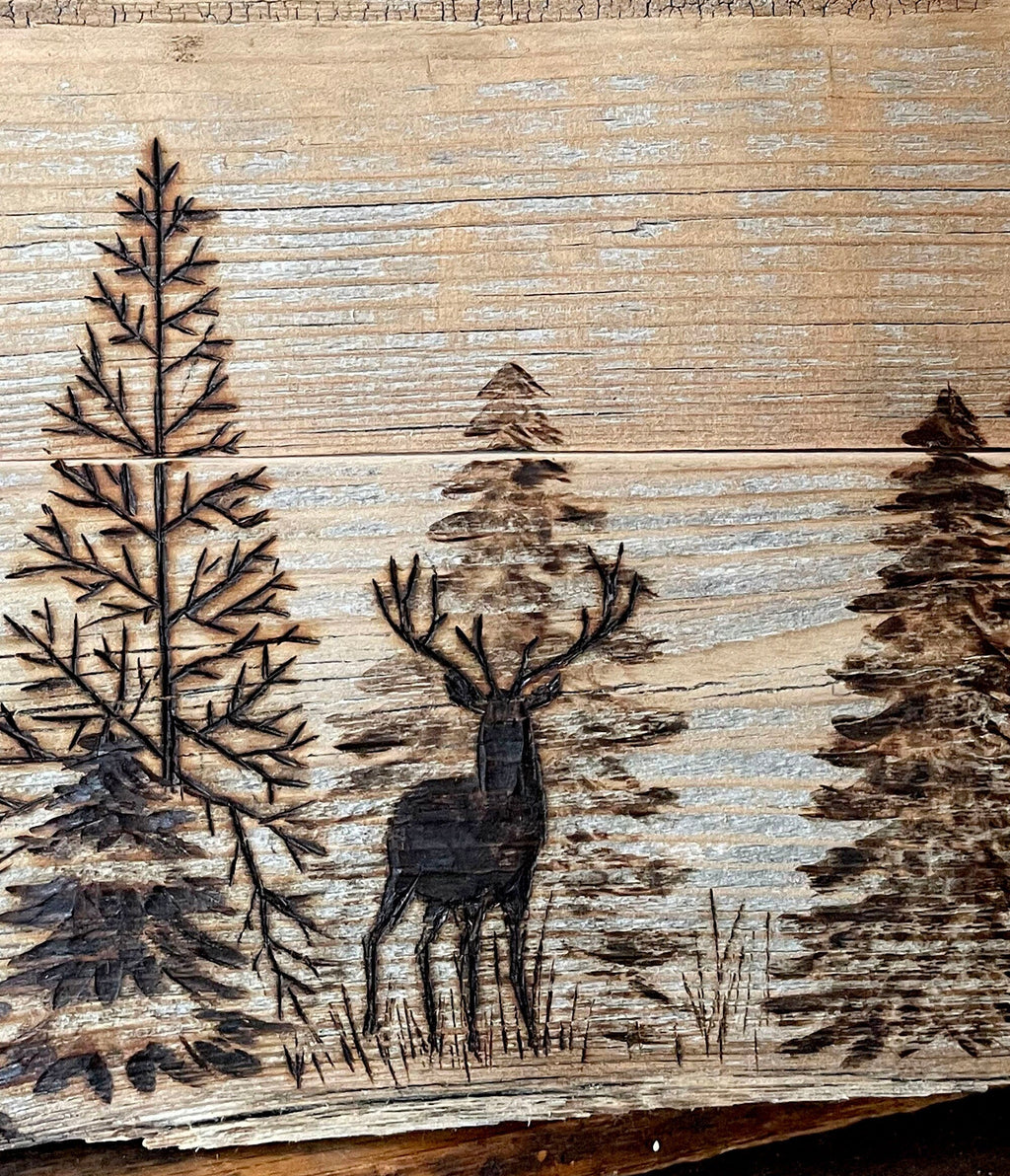 Wooden surface with engraved deer and trees, featuring the website www.boutiquebarn.net.