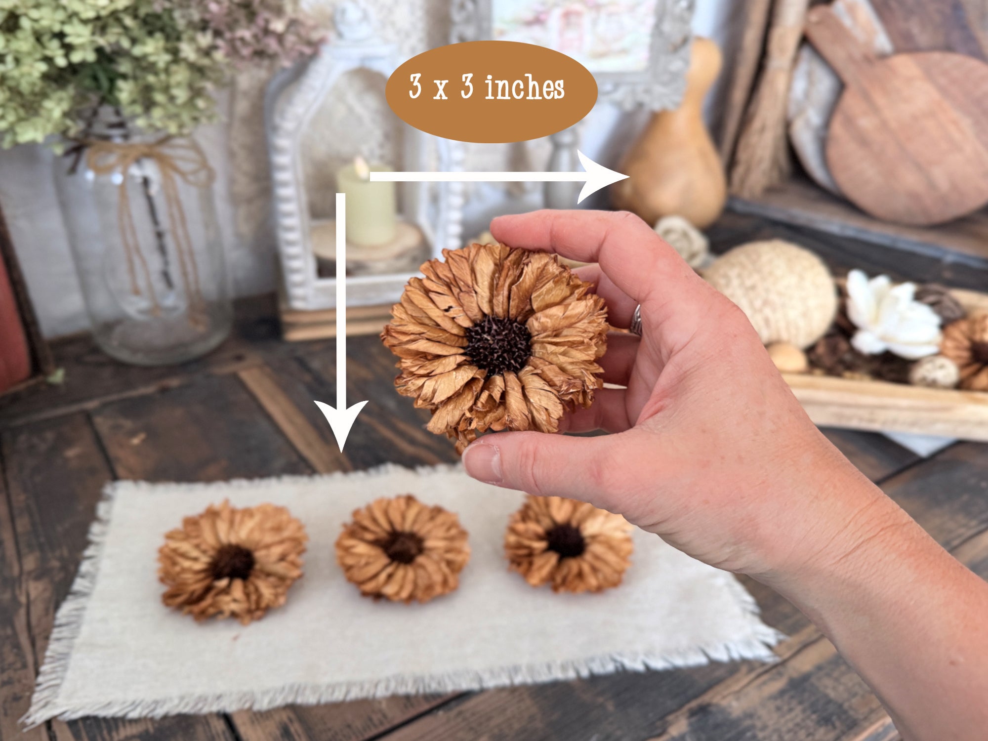 Hand holding a decorative sunflower with measurements on a wooden surface