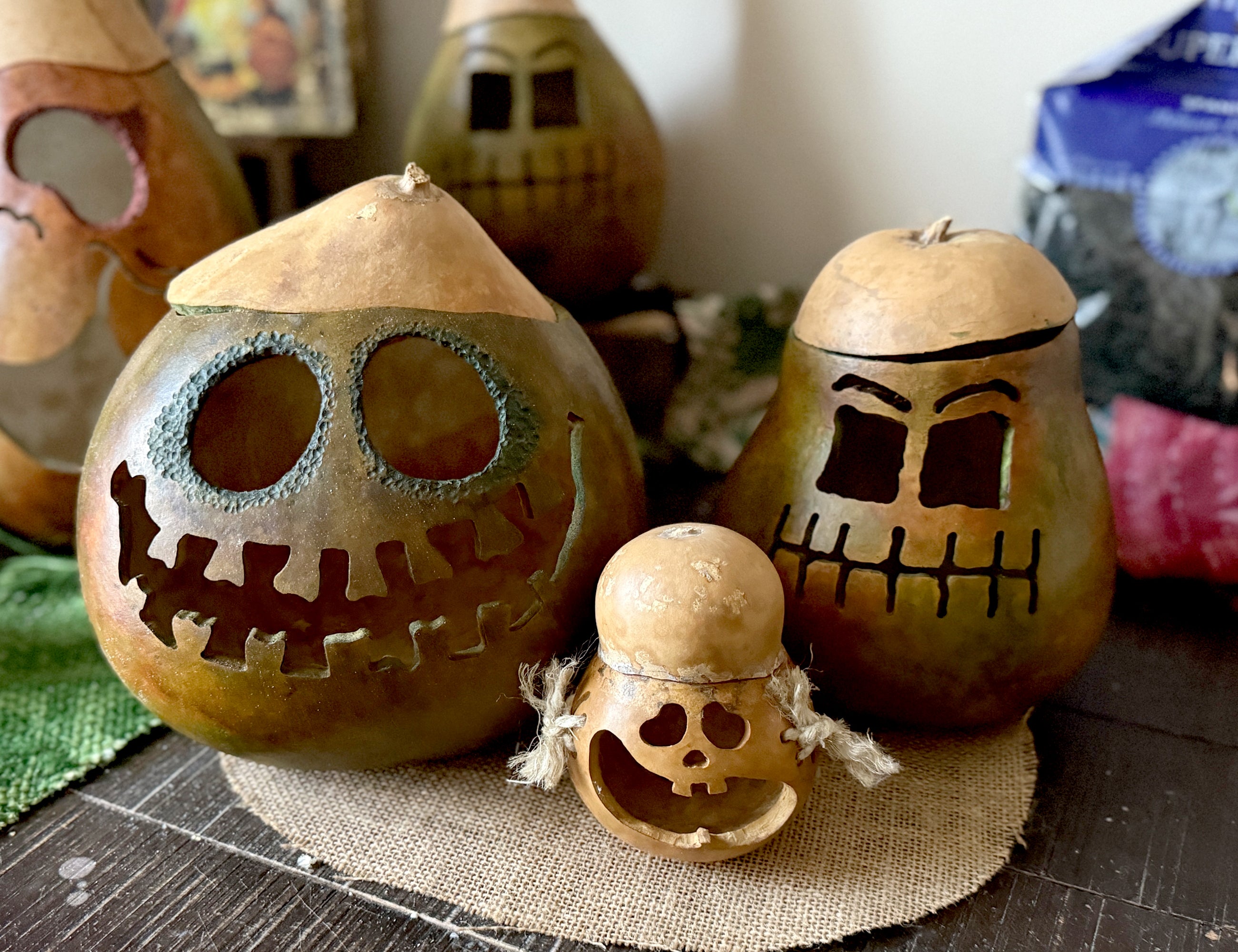 Gourd lanterns with carved faces on a wooden surface