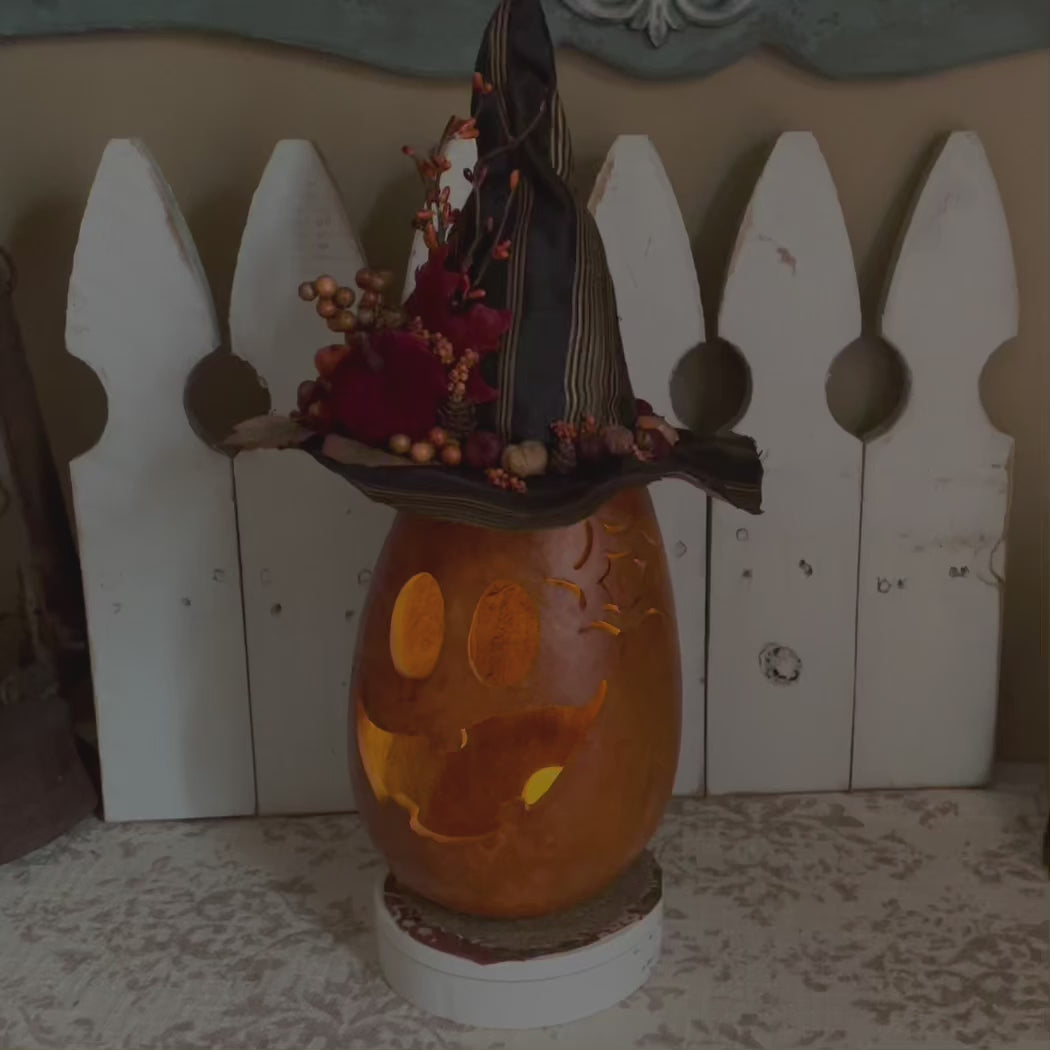 Pumpkin witch with candle and handmade black hat. 
