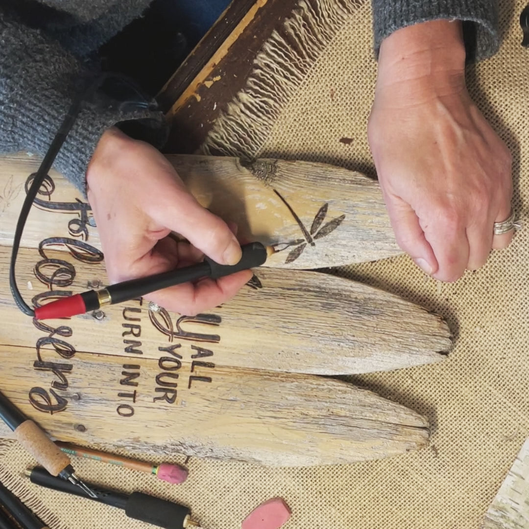 wood burning a dragonfly onto a old fence 