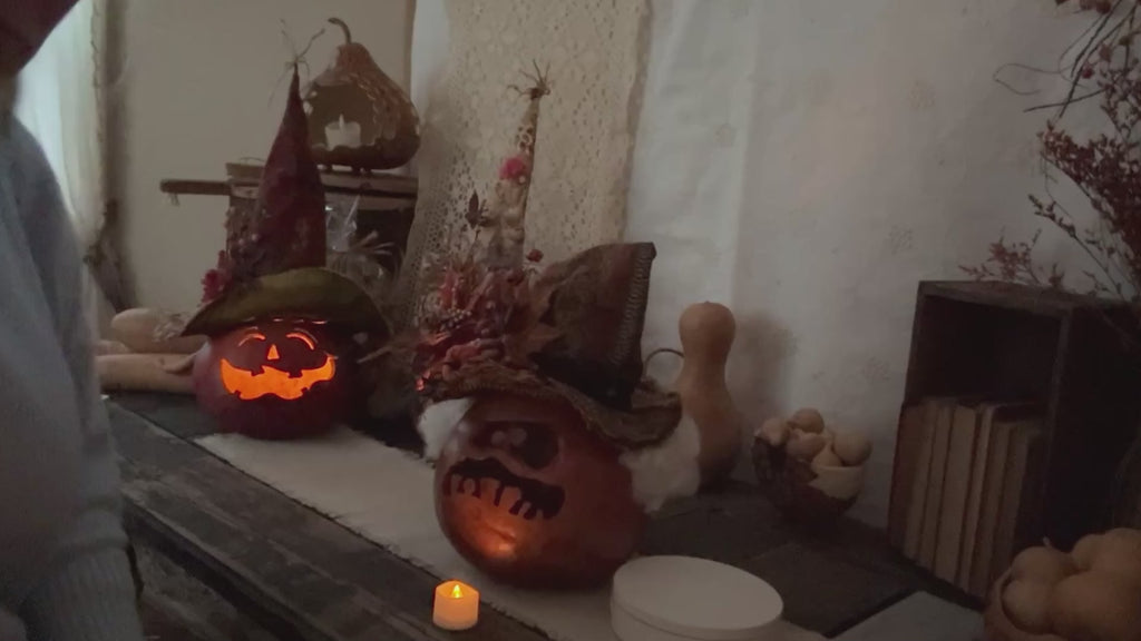 lighting a handmade ghostly pumpkin gourd