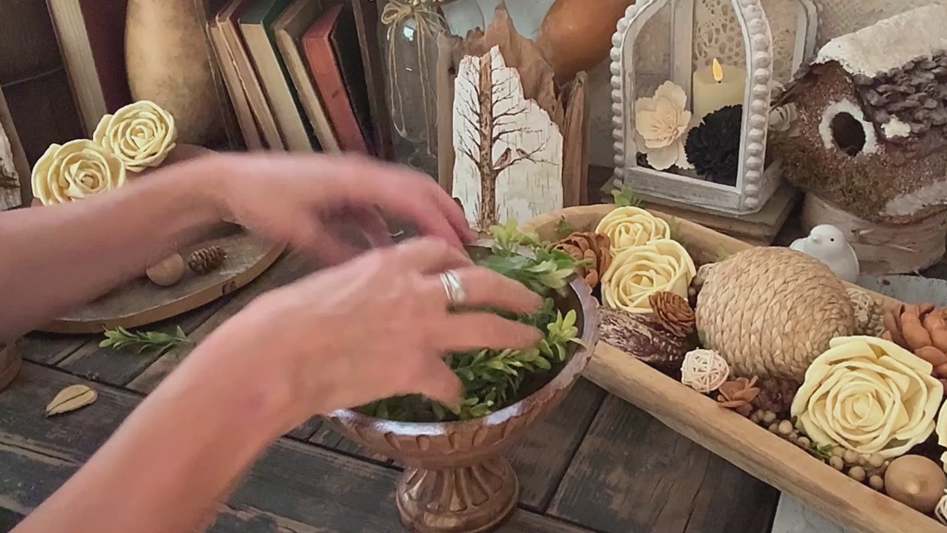 Video demo showing a teak wood bowl arrangement featuring green boxwood filler and wood flowers. 