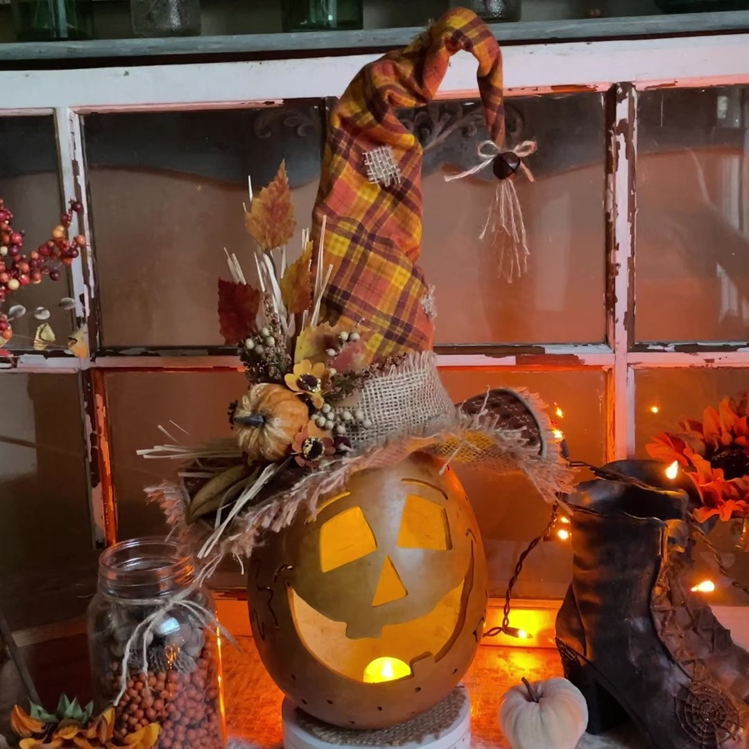 Hand carved pumpkin with custom hat and candle.