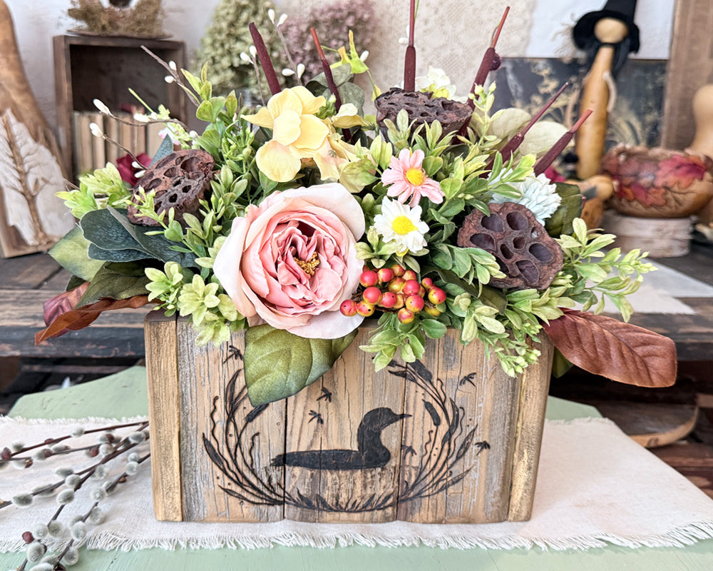 Rustic wooden box with summer flower arrangement and Hand drawn loon artwork on the front. 