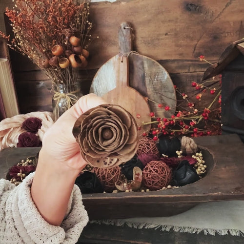 video showing natural filler arrangement in large wooden dough bowl featuring wood flowers in brown and black.