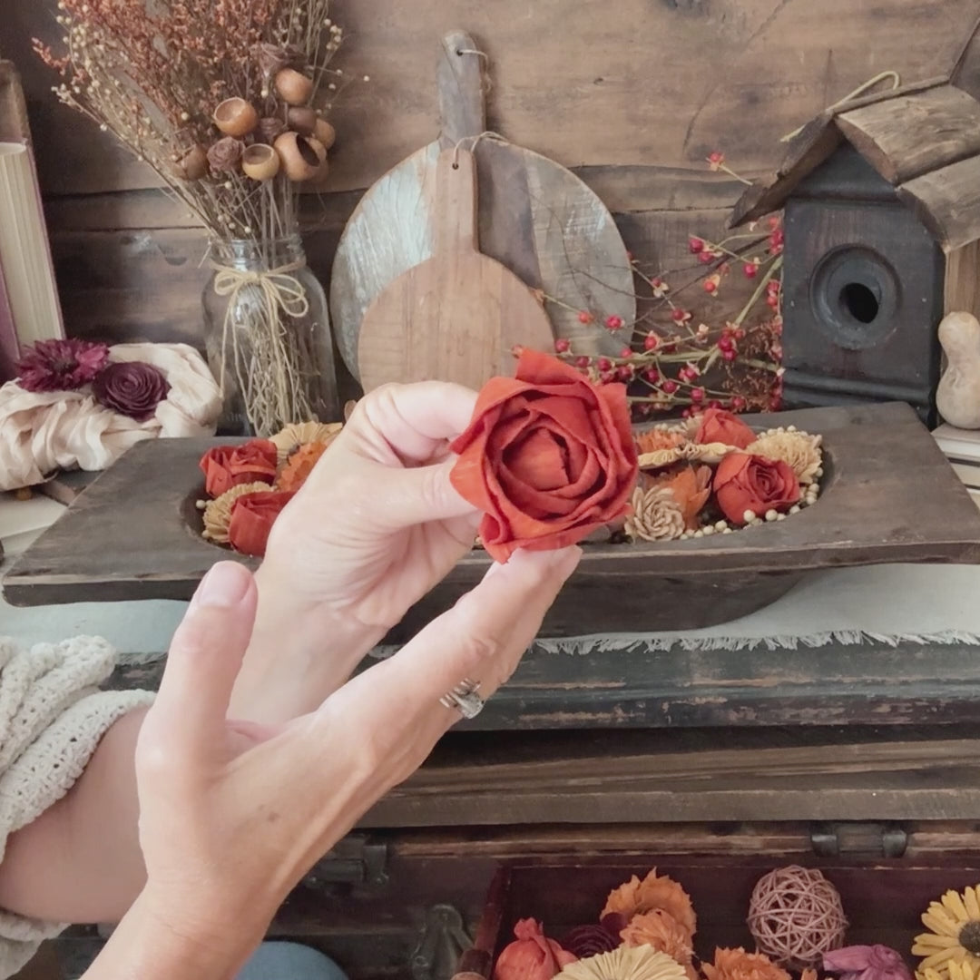 video showing a large wooden dough bowl arrangement of autumn colored wood flowers and berries
